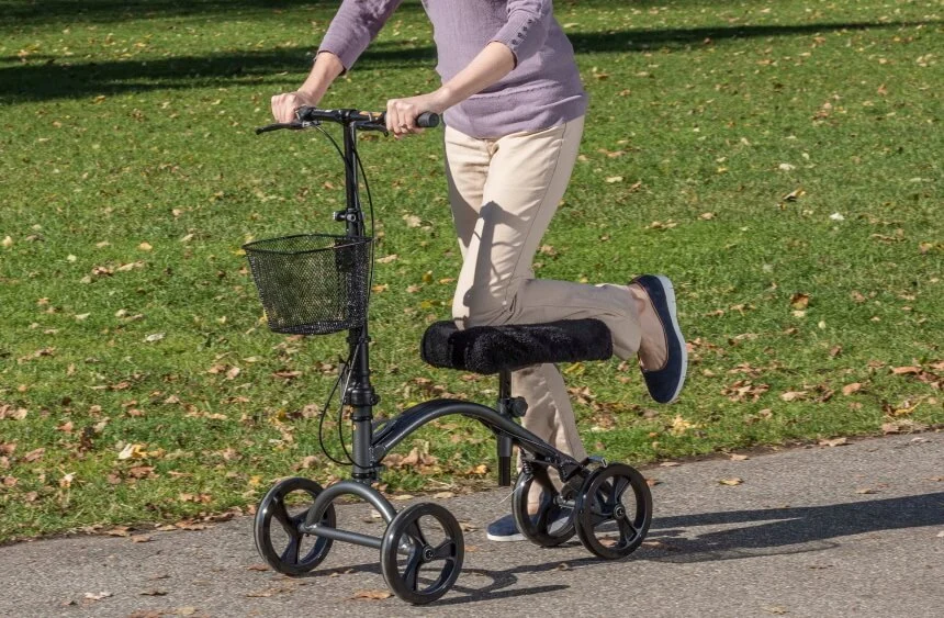 Elderly person learning to use a knee scooter effectively.