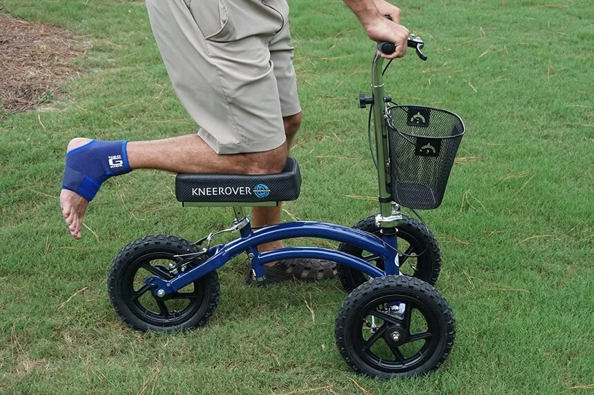 Senior balancing on a knee scooter for improved mobility.
