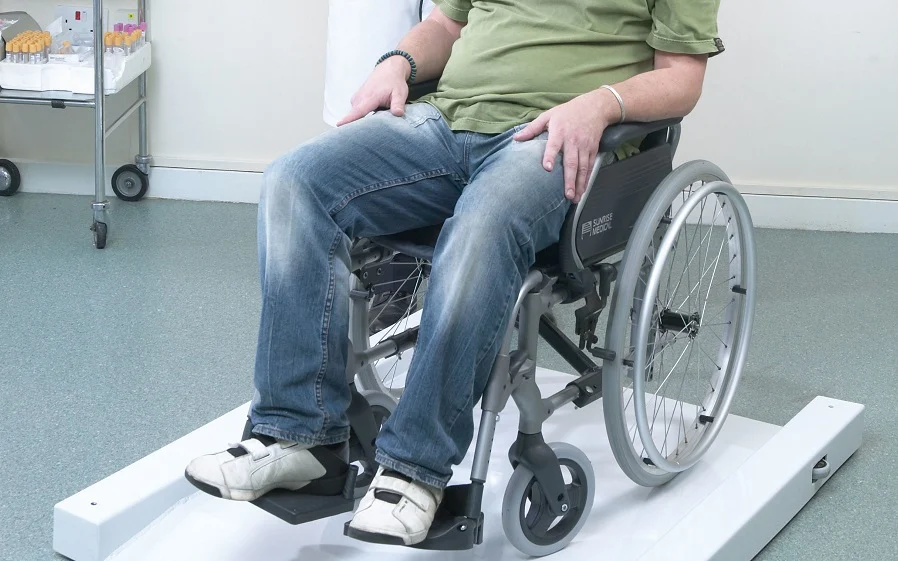 Demonstration of weighing a senior in a wheelchair using appropriate equipment.