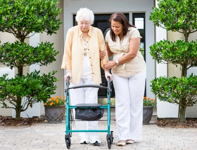 senior learning to use a walker with a trusted support worker
