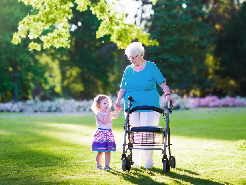 Senior woman walking with her grandchild using walker