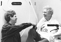 Nurse assisting elderly patient in long-term care setting